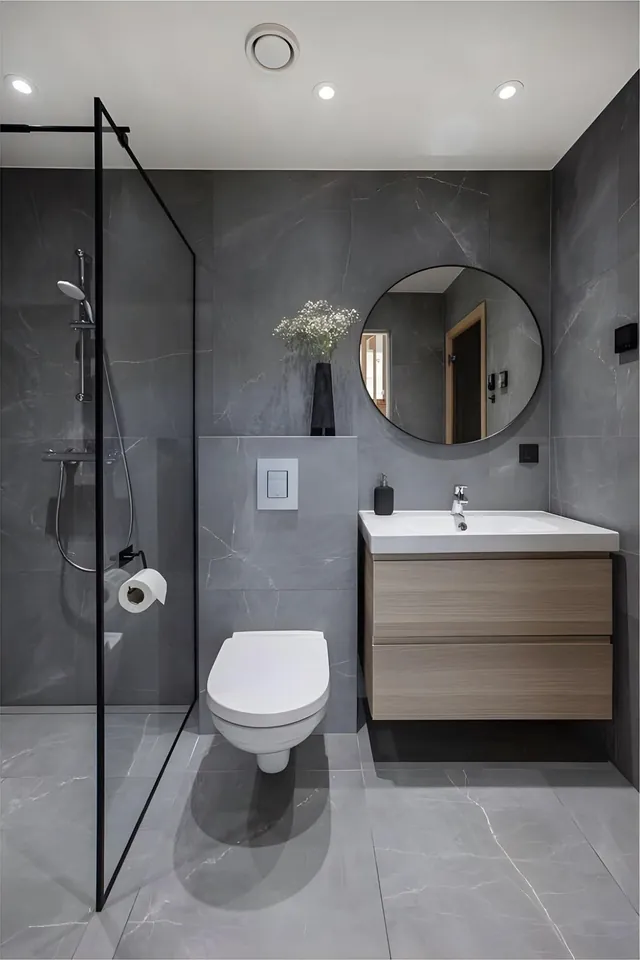 Bad in grauer Marmoroptik mit Walk-in-Dusche und Rundspiegel